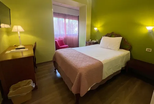 Single room at Fenix Hotel Roma with a three-quarter bed, writing desk and armchair
