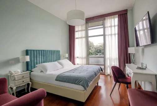Classic Double room at Fenix Hotel Roma with a double bed and a view of the greenery