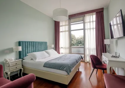 Camera Doppia Classic del Fenix Hotel Roma con letto matrimoniale e vista sul verde