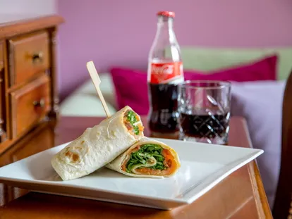 Filled wrap served in the room with a soft drink