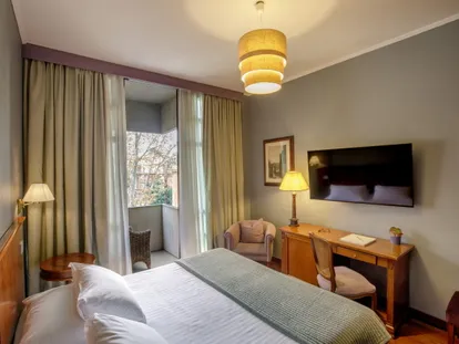 Executive Double room with writing desk, armchair and small balcony