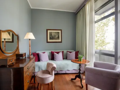 Sitting area of the Executive Double room with sofa, armchairs and a wooden dressing table with mirror