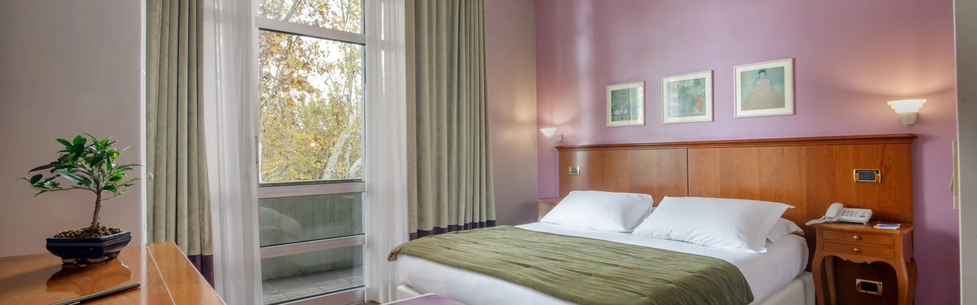 Executive Double room at Fenix Hotel Roma with a double bed and large windows overlooking the greenery
