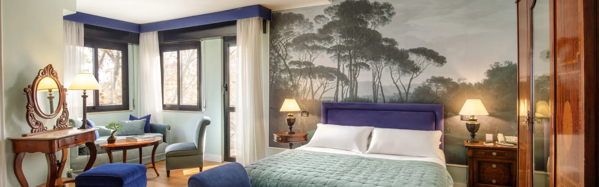 Camera Doppia Superior del Fenix Hotel Roma con carta da parati a pini, letto matrimoniale e dormeuse in velluto blu
