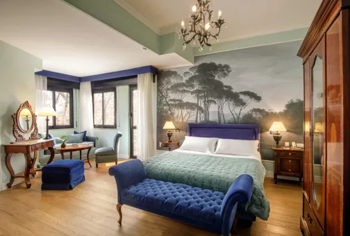 Superior Double room at Fenix Hotel Roma with pine-tree wallpaper, double bed and blue velvet chaise longue