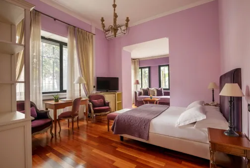 Junior Suite at Fenix Hotel Roma in shades of violet, with a double bed and sitting area