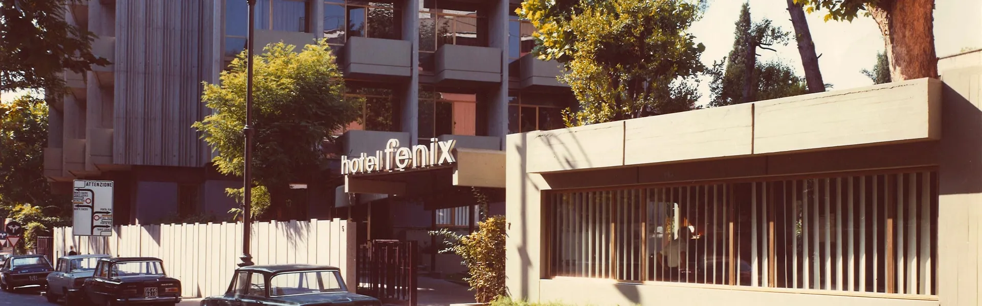 La facciata del Fenix Hotel a Roma in una foto d'epoca, con l'insegna storica e le auto parcheggiate davanti all'ingresso
